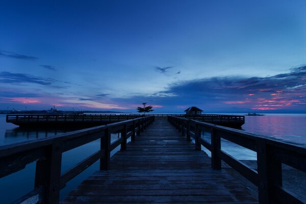 Muelle de madera en el fondo de la puesta de sol