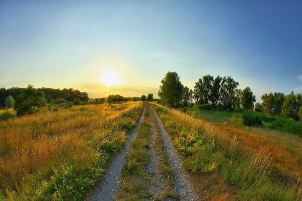 Landstraße im Feld bei Sonnenuntergang