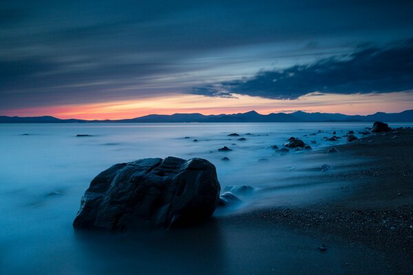 Sonnenuntergang am Meer. Leerer Strand mit Steinen