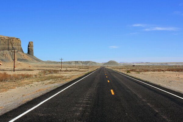 Autopista negra en el desierto con rocas