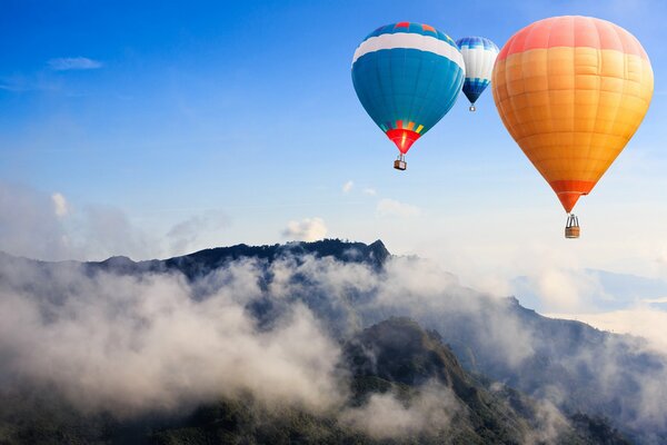 Balloons spoiling over mountains covered with fog