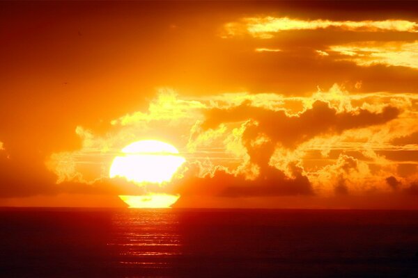 Coucher de soleil orange dans la mer parmi les nuages