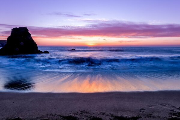 Côte rocheuse marine éclairée par le coucher du soleil
