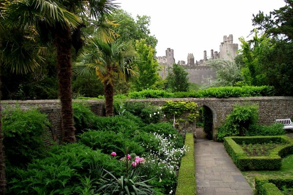 Stone park with trees and flowers near the castle