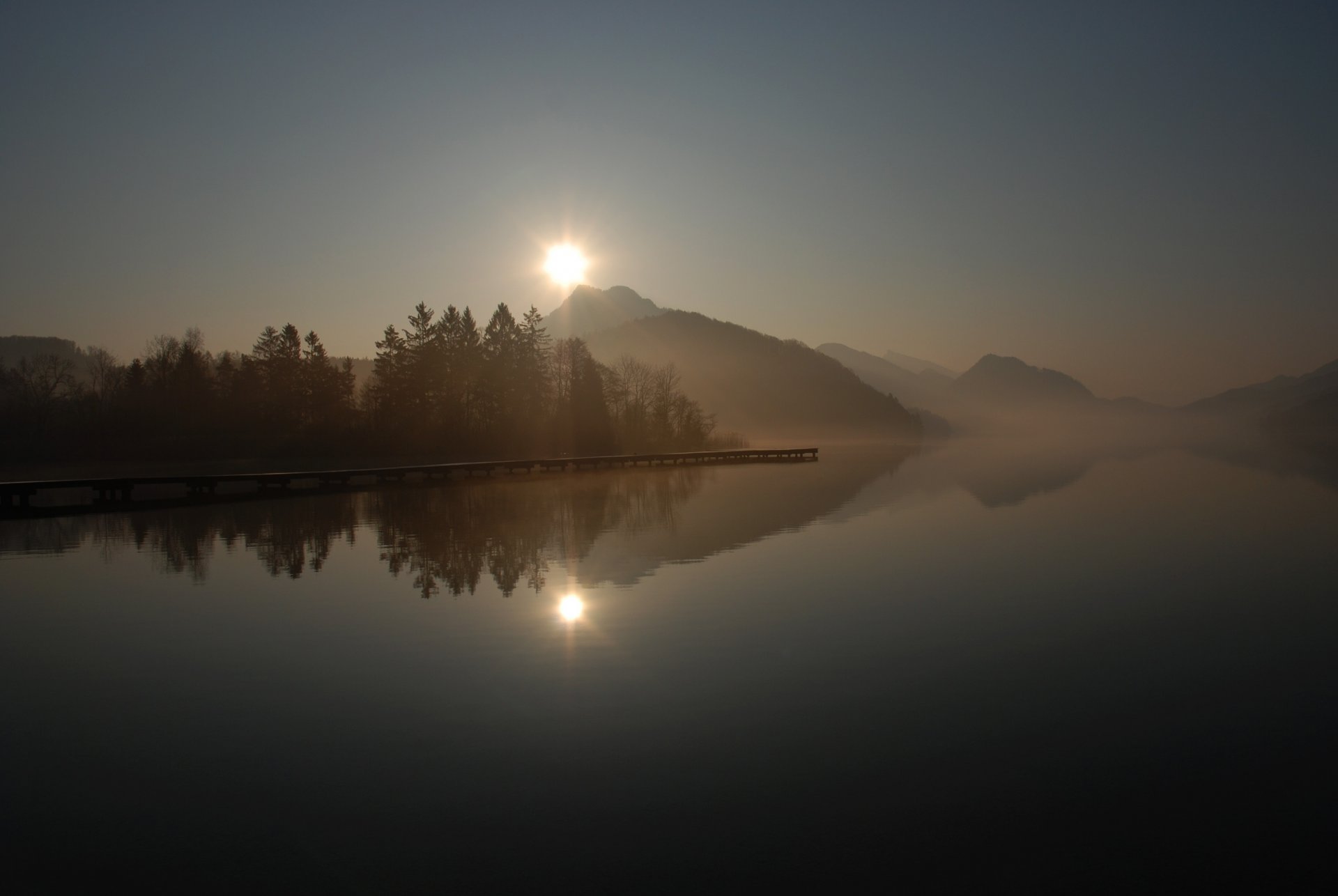 molo molo molo lago superficie riflessione colline nebbia alberi mattina sole alba