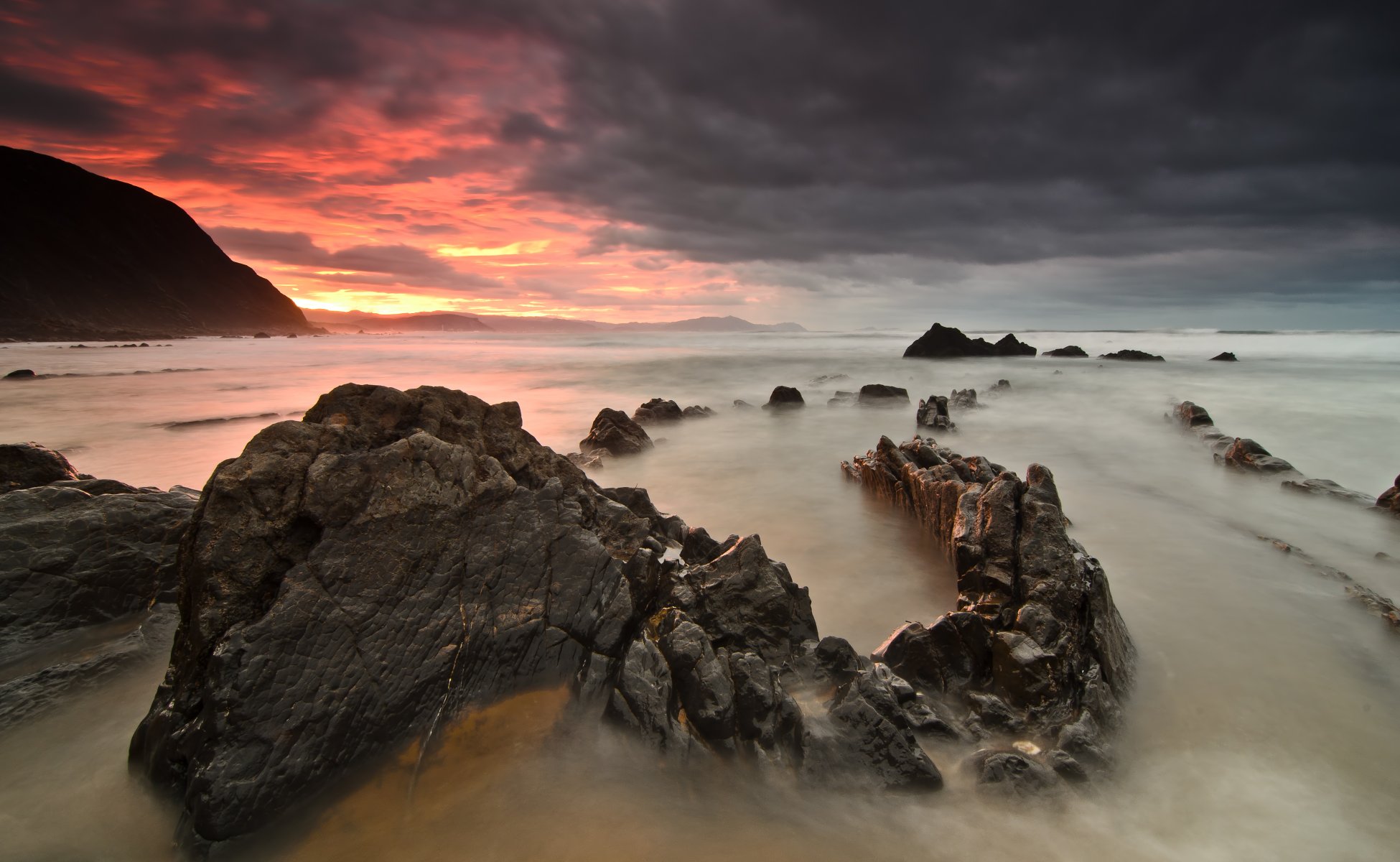 unset sea stones beach