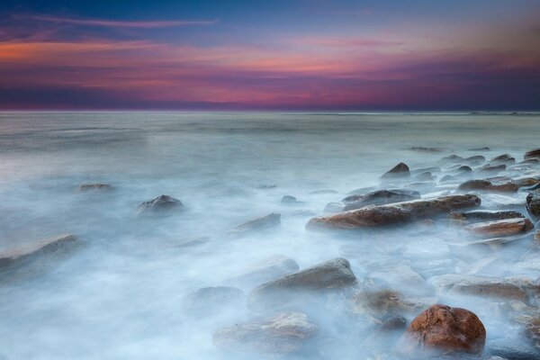 Calm sea with rocks and a beautiful sunset