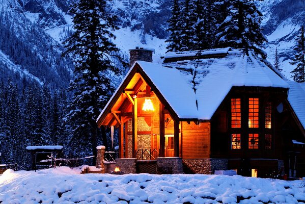 Maison dans la nature hivernale au milieu des montagnes et des arbres