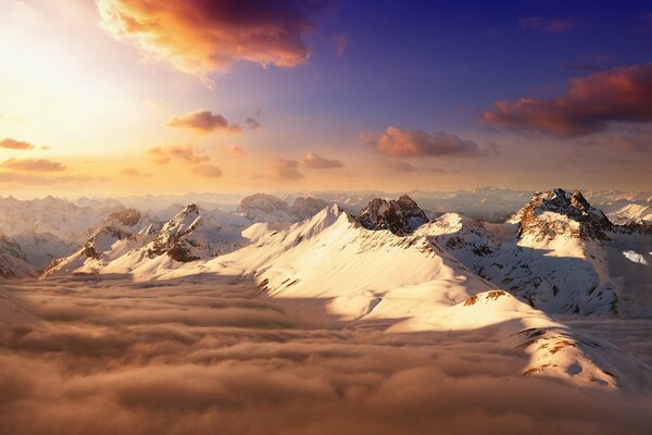 Cimas de montañas nevadas bajo las nubes