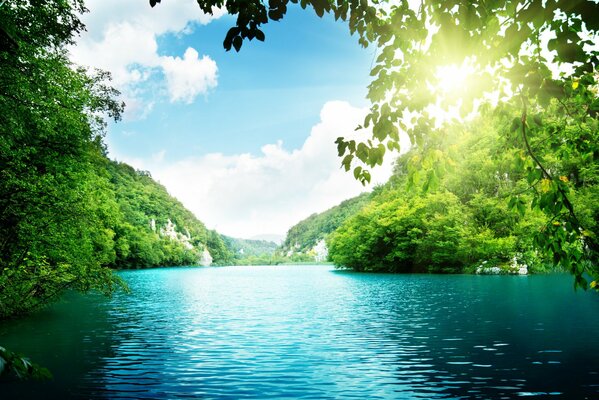 Landschaft. Die Sonnenstrahlen durch die Blätter der Bäume fallen auf den See