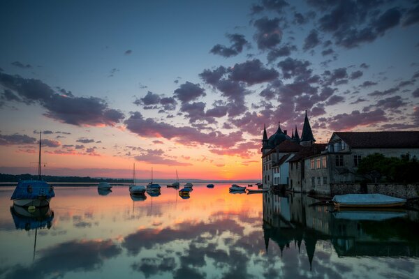 Maison près de l eau et un bateau au coucher du soleil