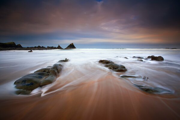 Stones on the beach in the water with exposure