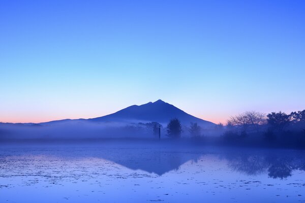 Reflexion des abendblauen Himmels und des Berges