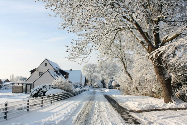 Tranquilla strada innevata con case bianche