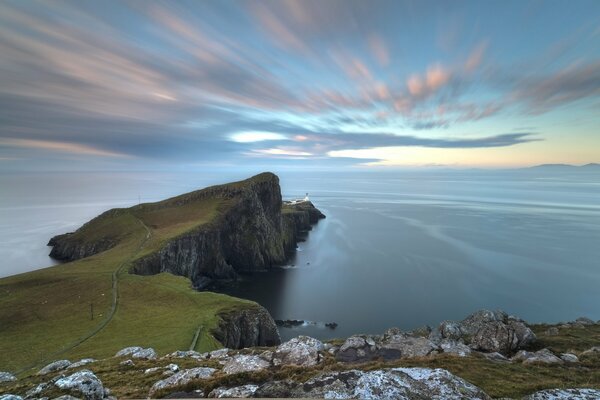 Dynamic photo with clouds and a rock protruding far into the ocean