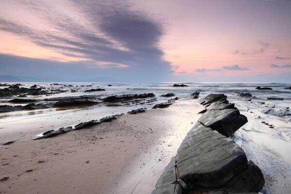 A picture of the sea with a beach and baths