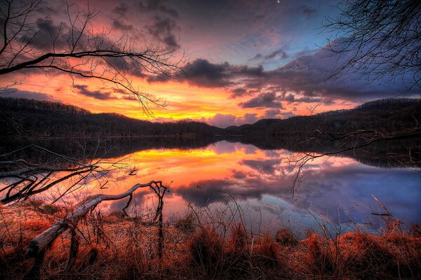 Puesta de sol ardiente, reflejo en el lago