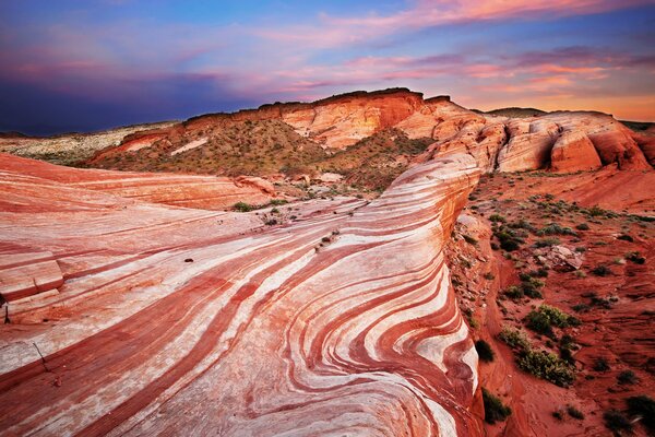 Puesta de sol sobre el desierto rocoso rojo