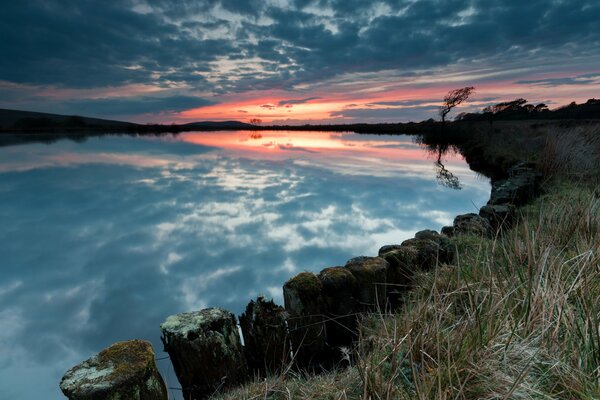 Puesta de sol roja en el lago brumoso