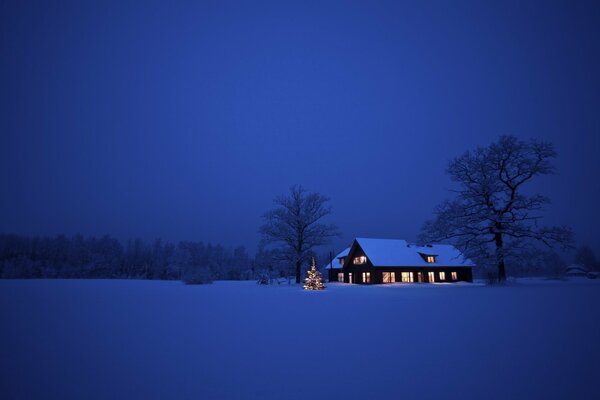 Maison debout dans une vallée enneigée dans la nuit de Noël
