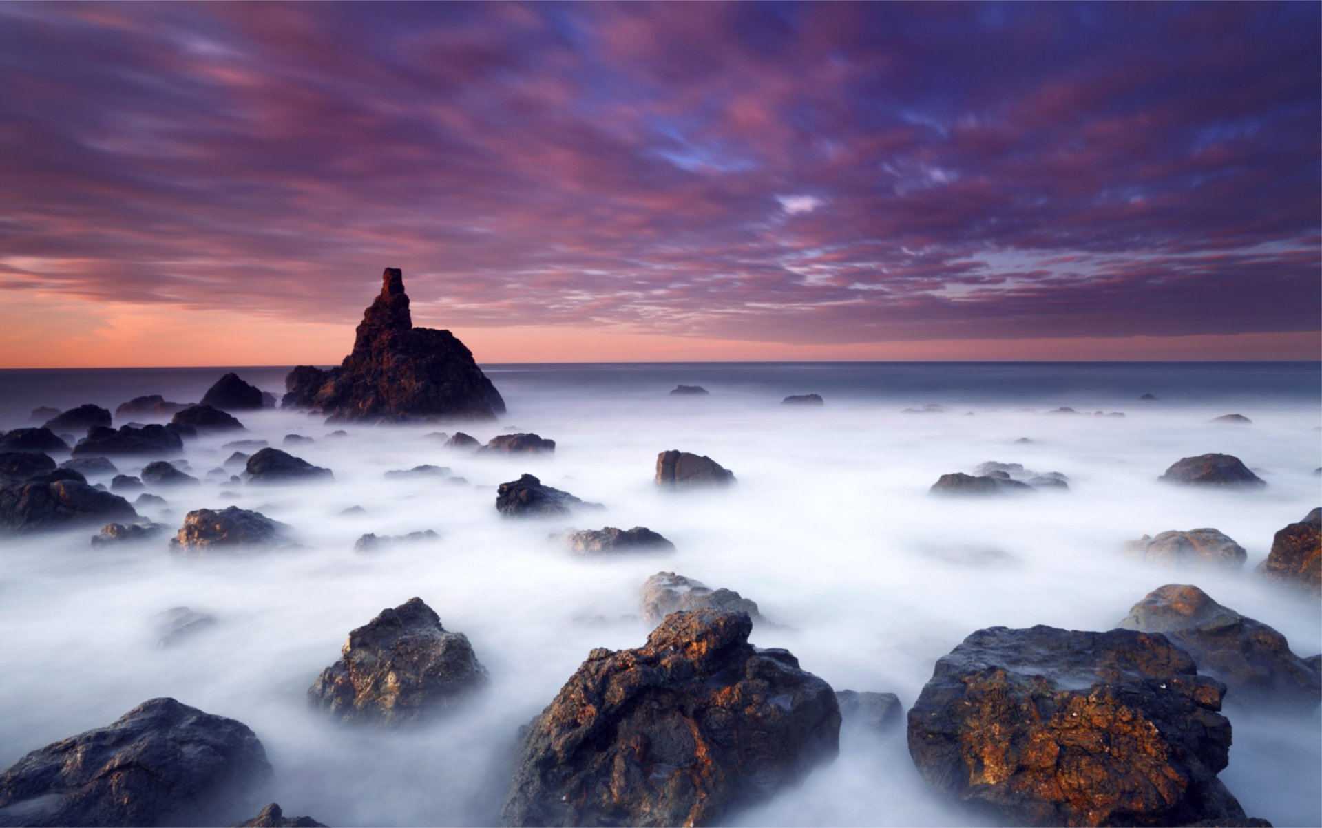 night sea ocean beach stones blue sky clouds orange sunset