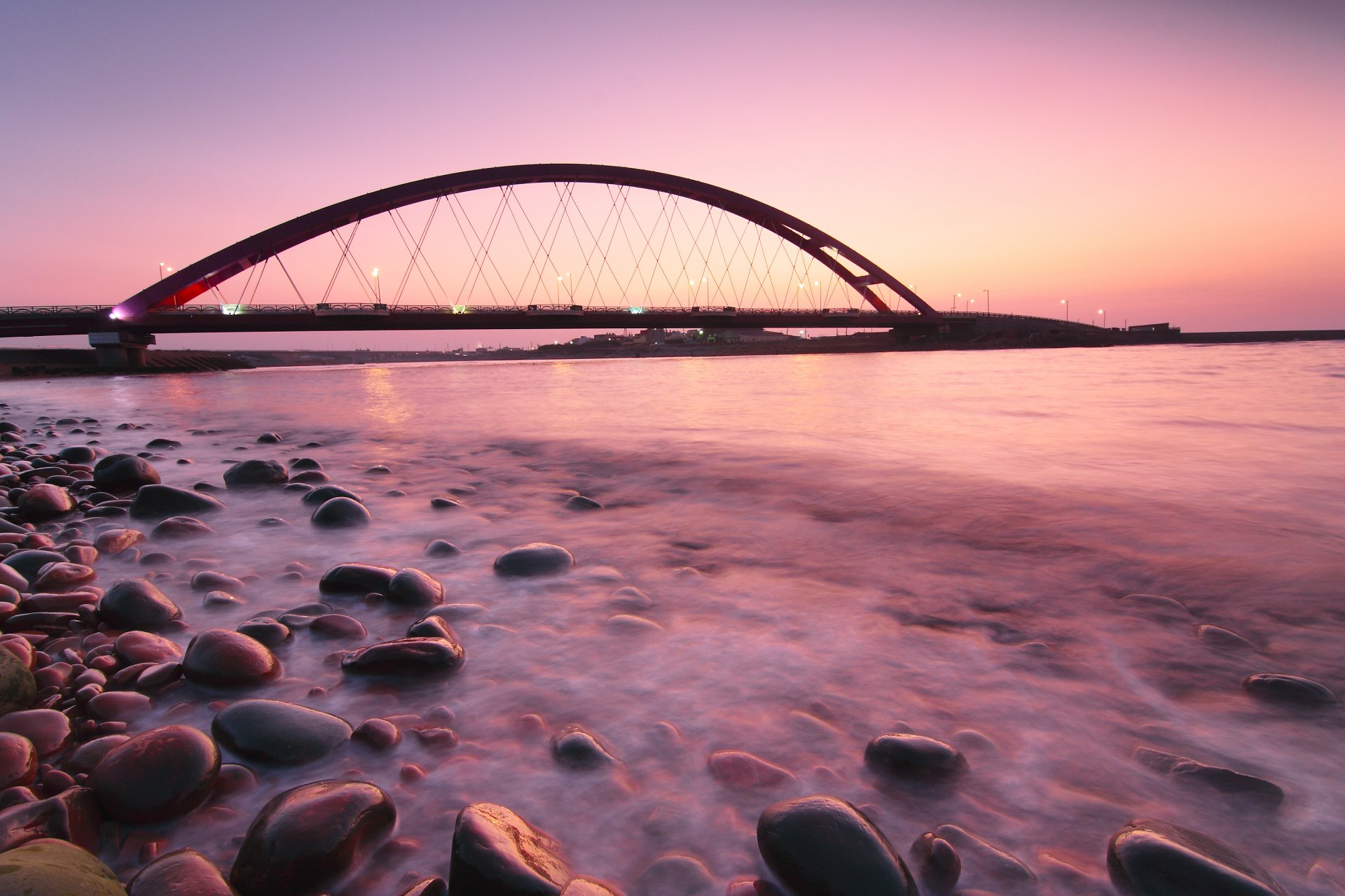 germany fehmarnsund bridge pink sunset night bridge lamps light sea ocean calm beach stone