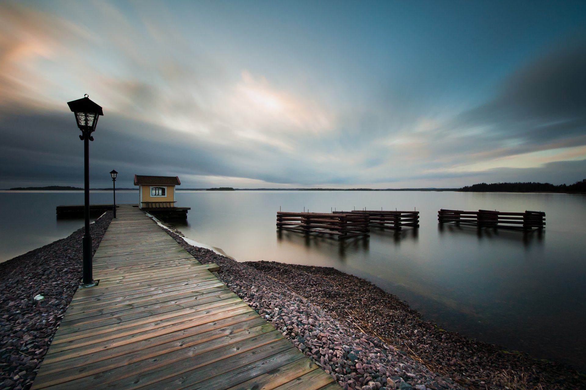 weden night sky clouds sea calm water surface of beach coast pier lamp