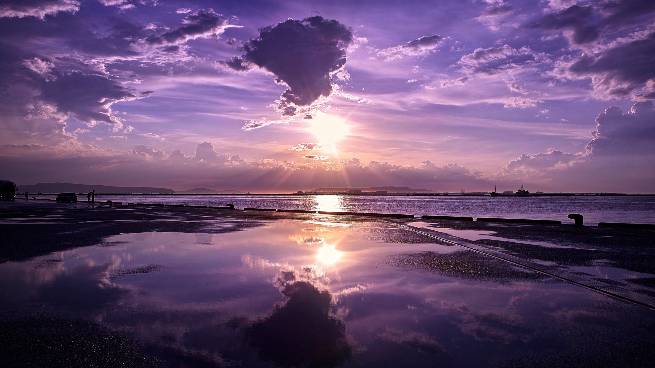 meer ozean küste pier pier pier ferne horizont himmel wolken sonnenuntergang wasser glatte oberfläche reflexion menschen schiffe berge