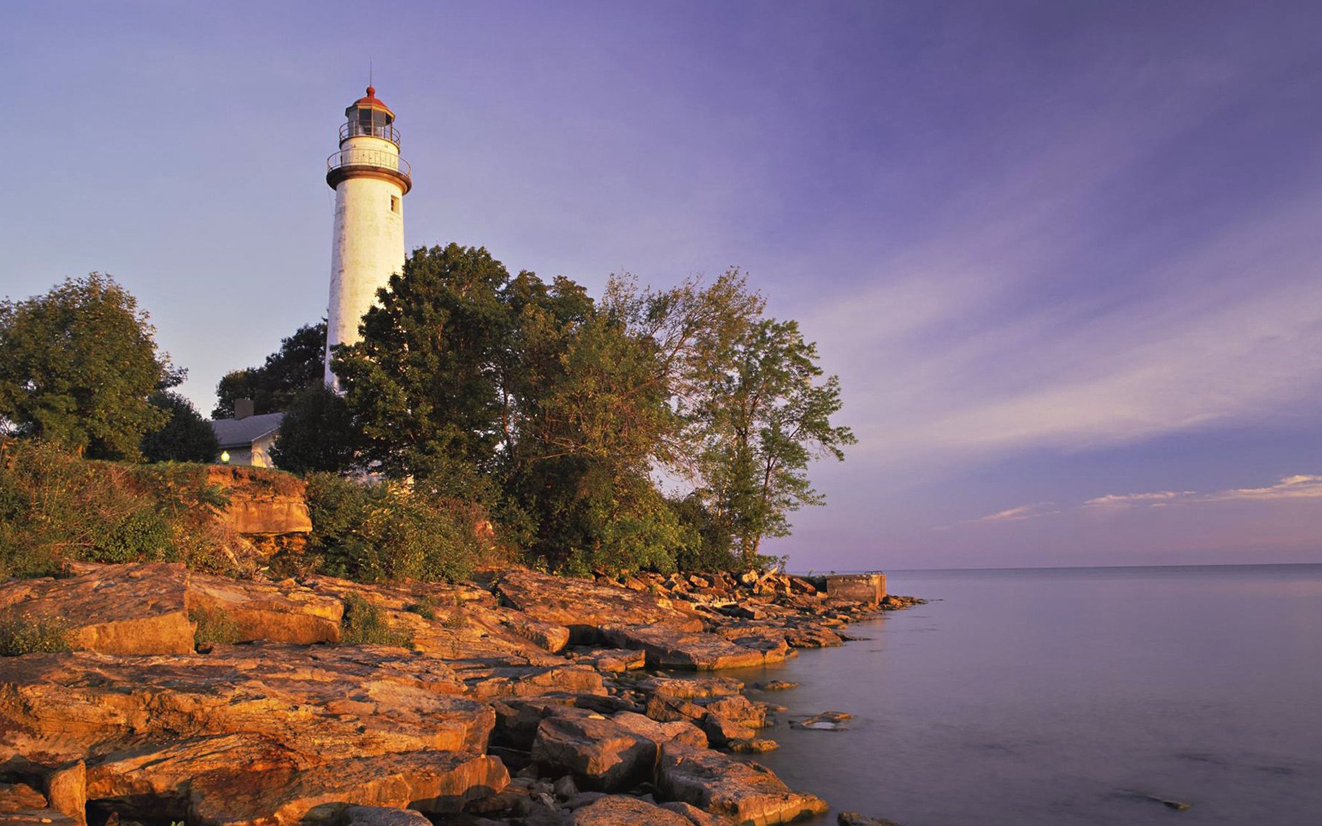 lighthouse beach stones tree lake lilac sky