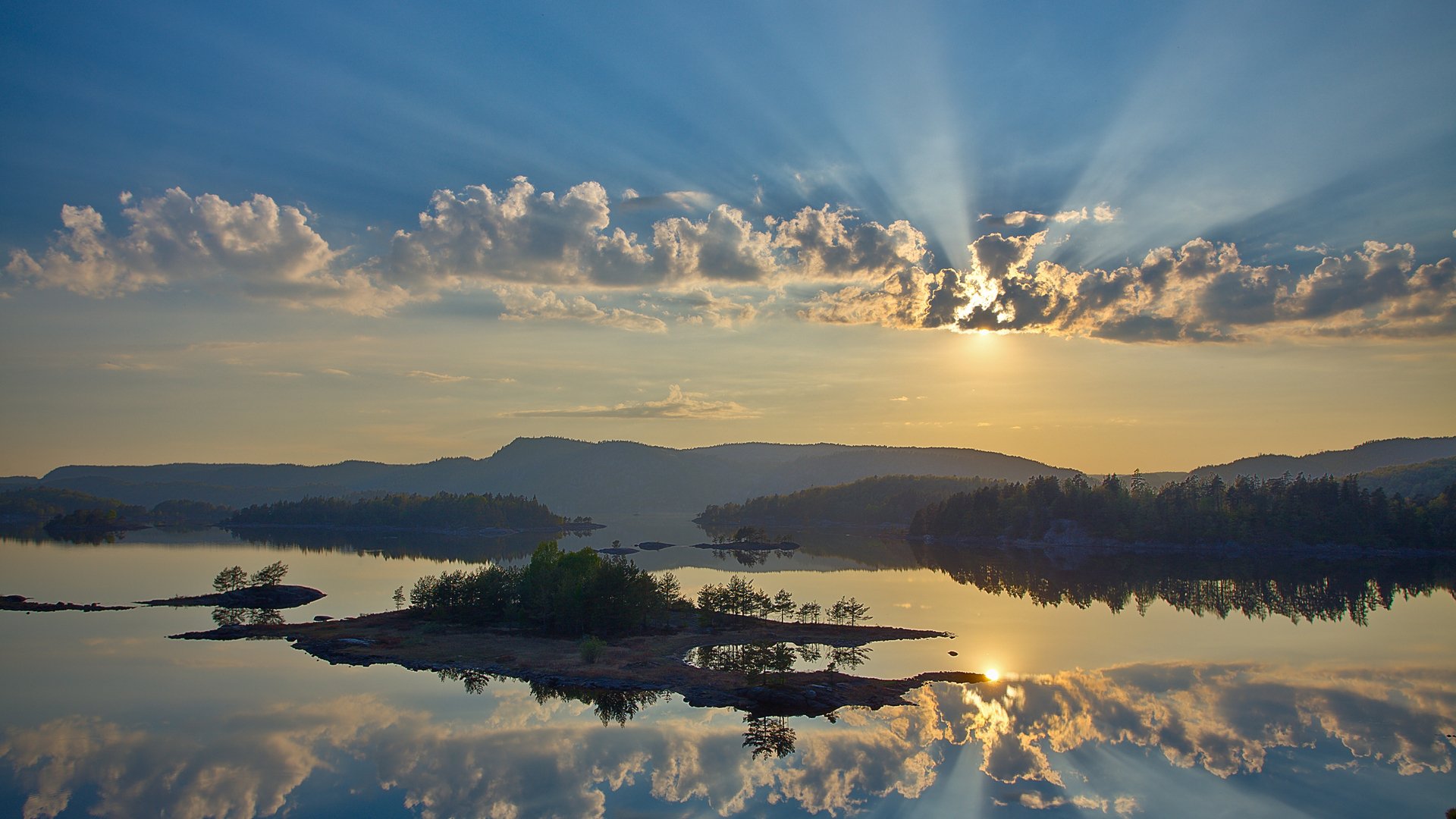 mountains river forest trees sky clouds sun rays light islands islets smooth surface reflection mirror beauty