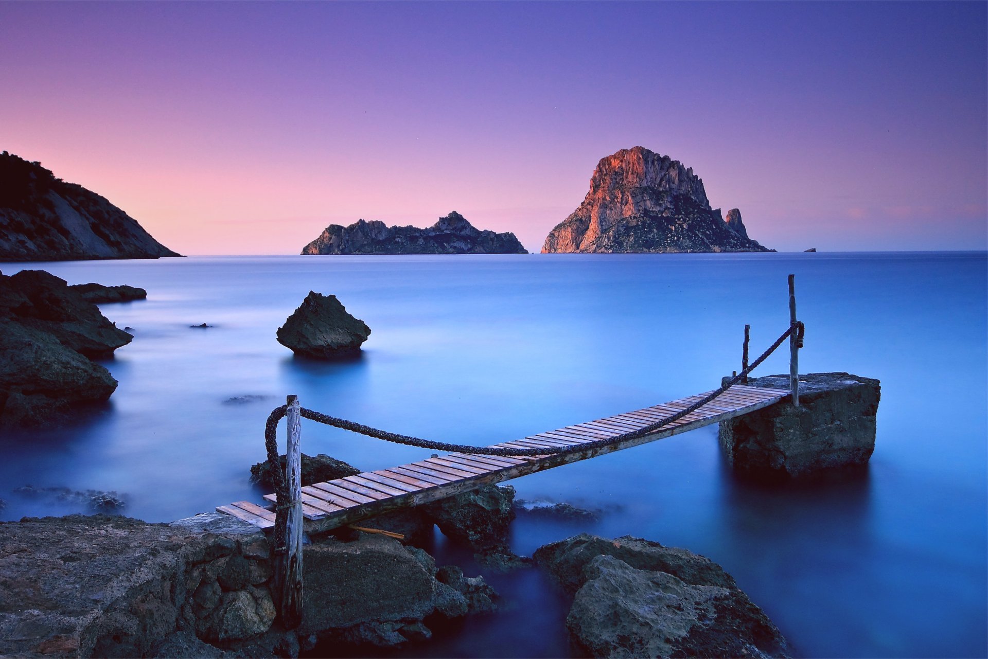 soir rose coucher de soleil lilas ciel montagnes rochers pierres côte en bois pont chaînes mer océan bleu calme