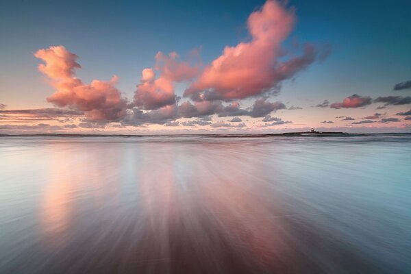 Pink clouds are reflected in the sea surface