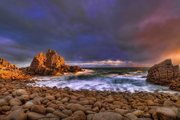 Evening surf in the ocean. Rocks on the shore