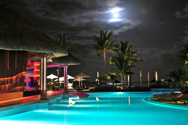 The night sky over the pool with palm trees