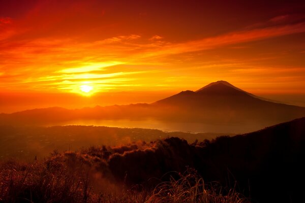 Pomarańczowy zachód słońca otaczający góry