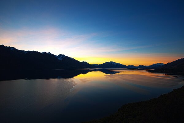 The sun sets over a mountain lake