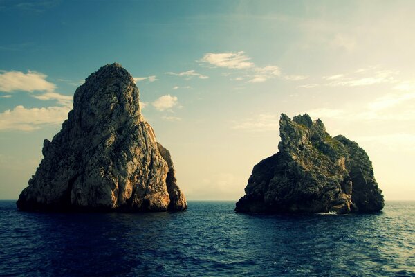 Es gibt zwei Felsen im Meer und einen Himmel
