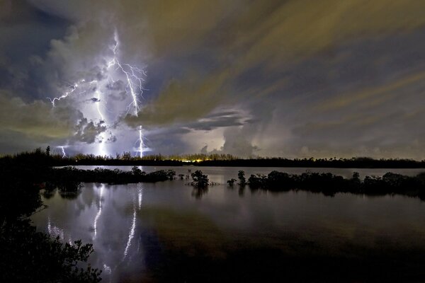 Tormenta nocturna en la distancia sobre el lago