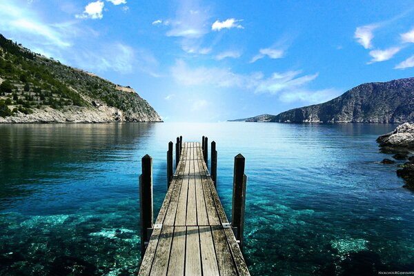 A bridge over the blue sea leading straight into the sky