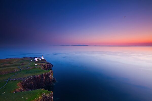 Lighthouse on a rock at sunset looks mysterious