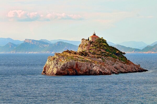 Lonely island in the middle of the ocean beautiful photo with a lighthouse