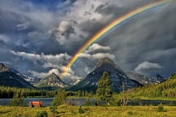 Hermoso arco iris entre el cielo sombrío en las montañas