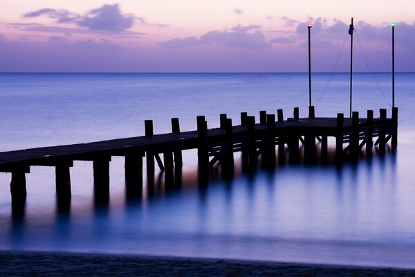 Holzpier auf dem Hintergrund der Dämmerung