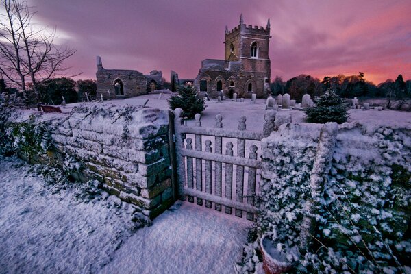 Church with cemetery in winter at sunset