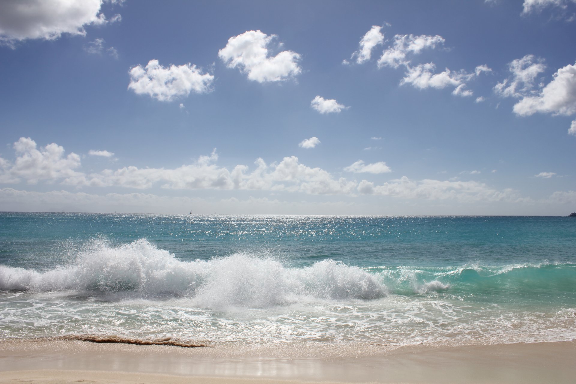 un sea waves spray sky horizon clouds sand