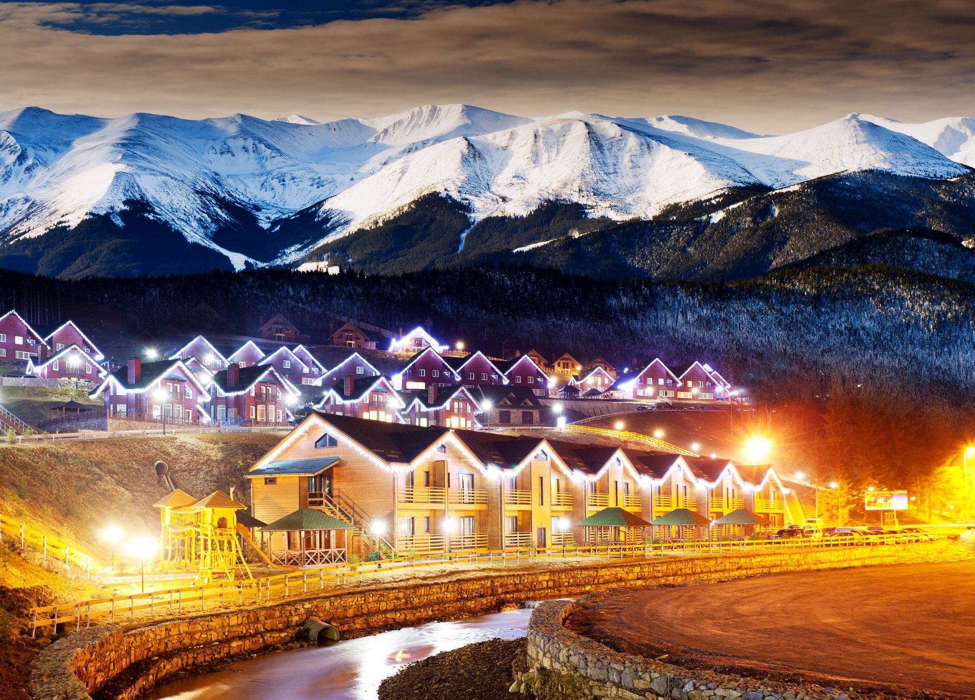 in the countryside winter highlands winter village night houses lights forest snow-covered mountains cloud