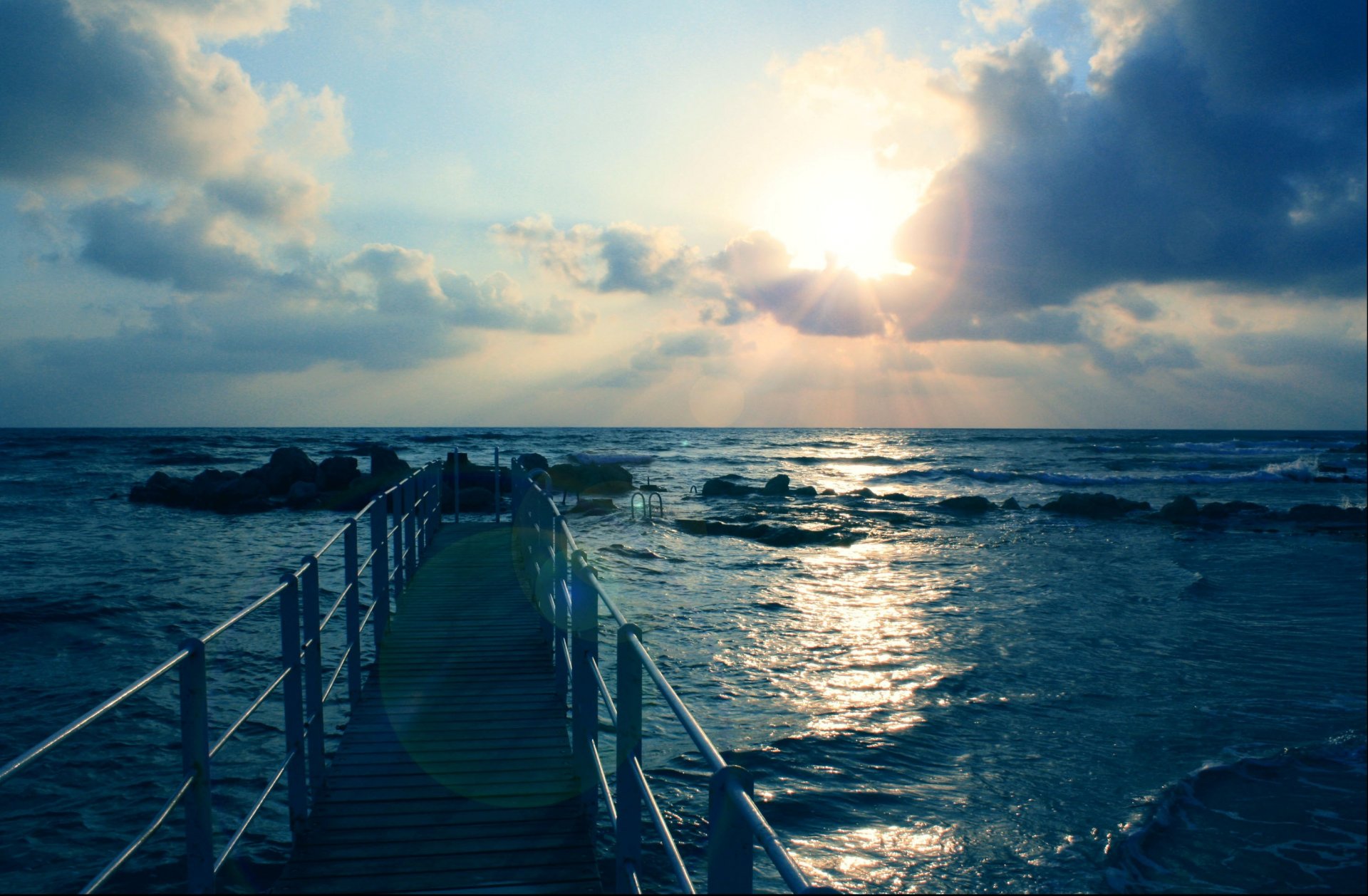 paesaggio mare onde pietre molo cielo sole nuvole raggi carta da parati