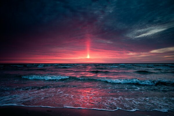 Czerwony zachód Słońca w falach morskich