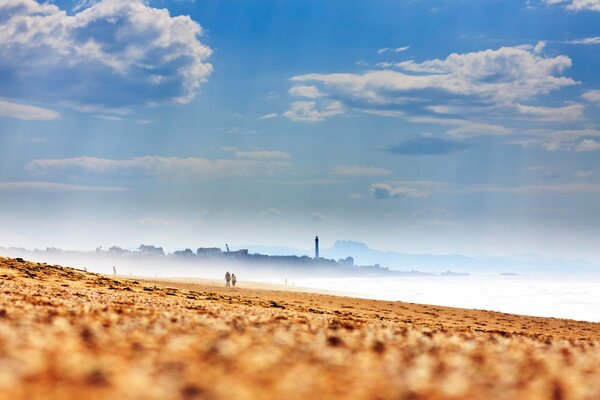 Phare dans la brume brumeuse sur la côte de sable de la France