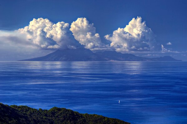Barca a vela In mare sullo sfondo di montagne e nuvole